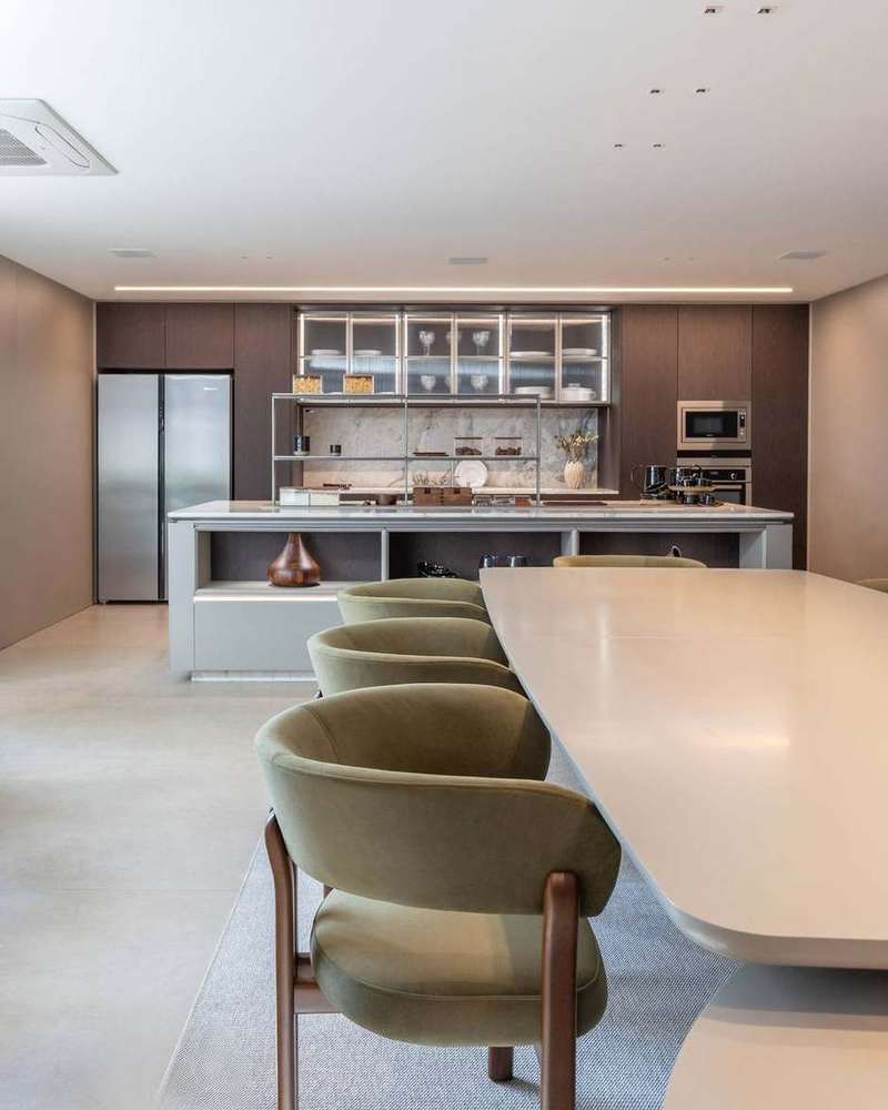 Cozinha planejada com ilha em mármore, marcenaria clara e prateleiras abertas, projeto Marel Alphaville