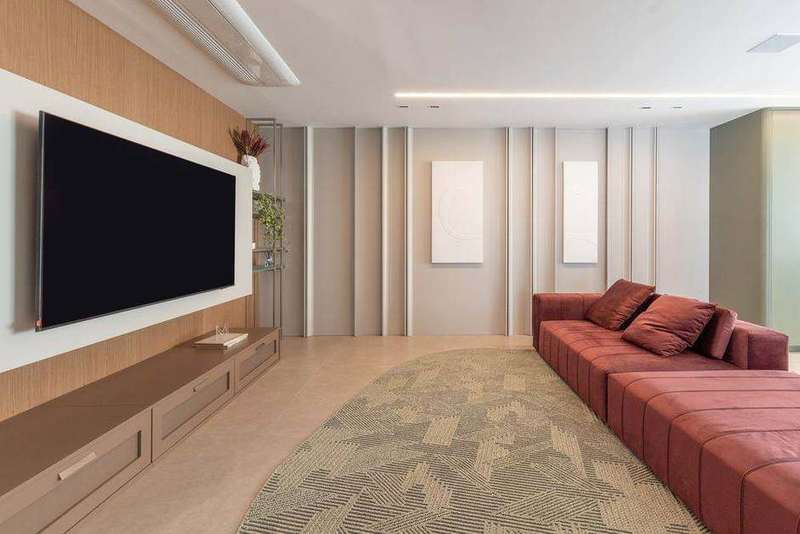 Living com painel ripado em madeira, rack suspenso e marcenaria de apoio, projeto Marel Alphaville