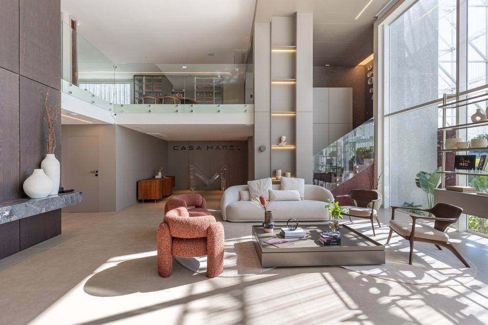 Living de pé-direito duplo com marcenaria integrada e detalhes em mármore bordô, Casa Marel