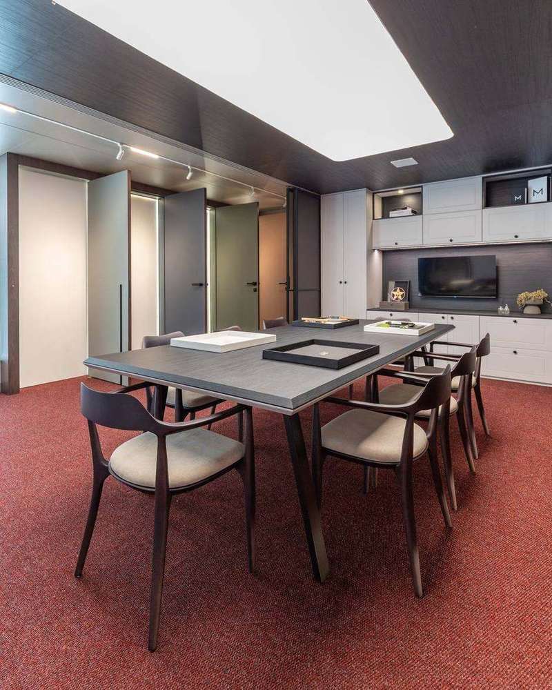 Sala de projeto da Marel Alphaville com parede de amostras de acabamentos e mesa de reunião
