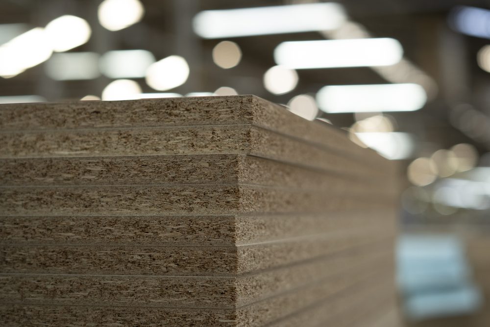 Estoque de painéis de MDF em prateleiras altas dentro da fábrica da Marel